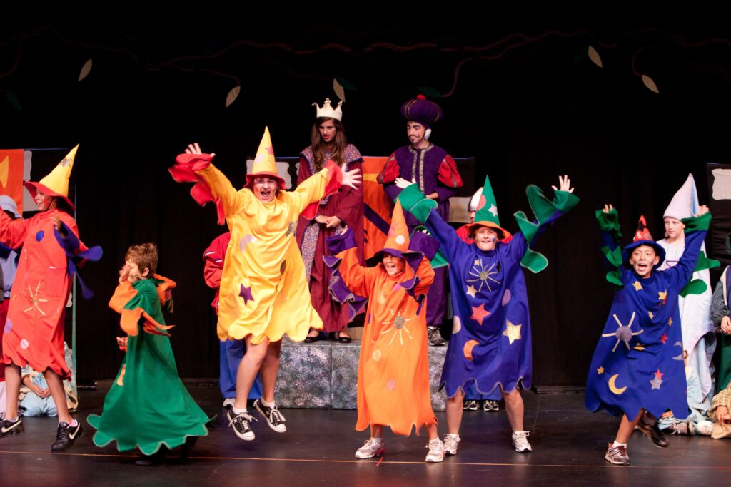 Photo of young performers on stage in wizard costumes.