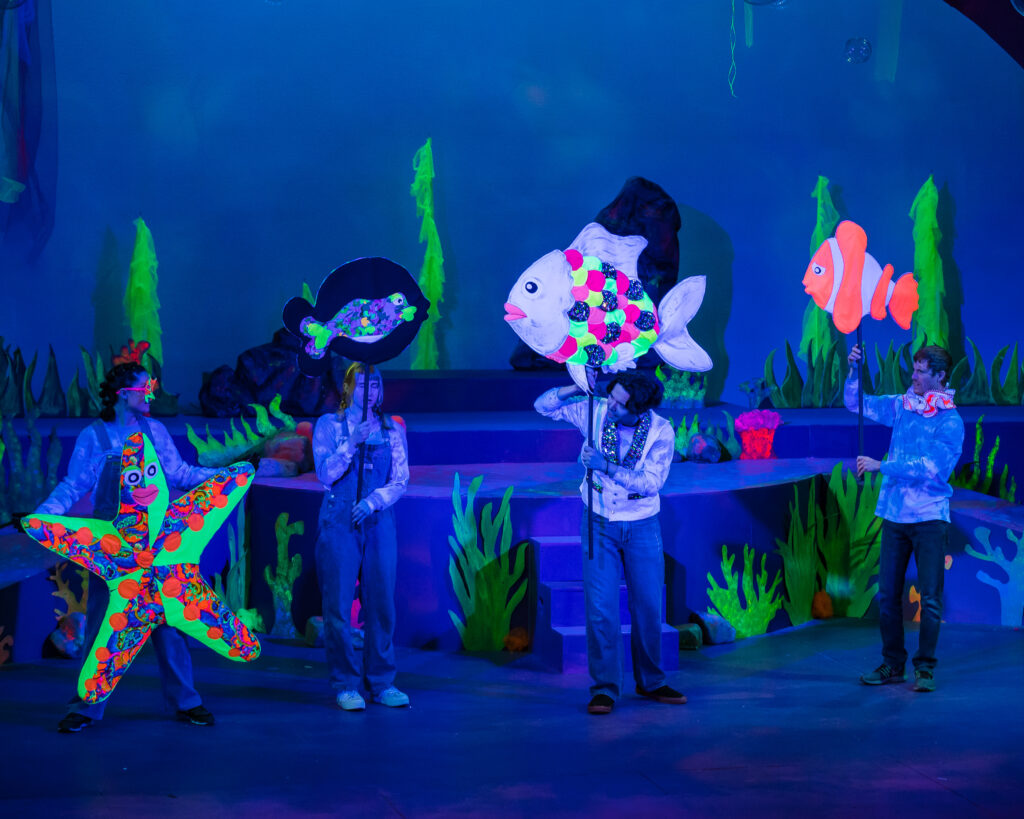 Group of young performers performing an underwater scene from Finding Nemo.